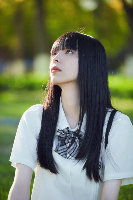 在户外草坪看书学习的女生