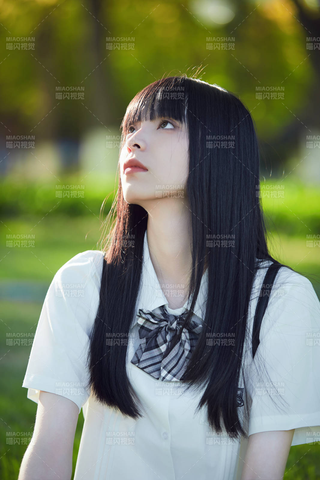 在户外草坪看书学习的女生