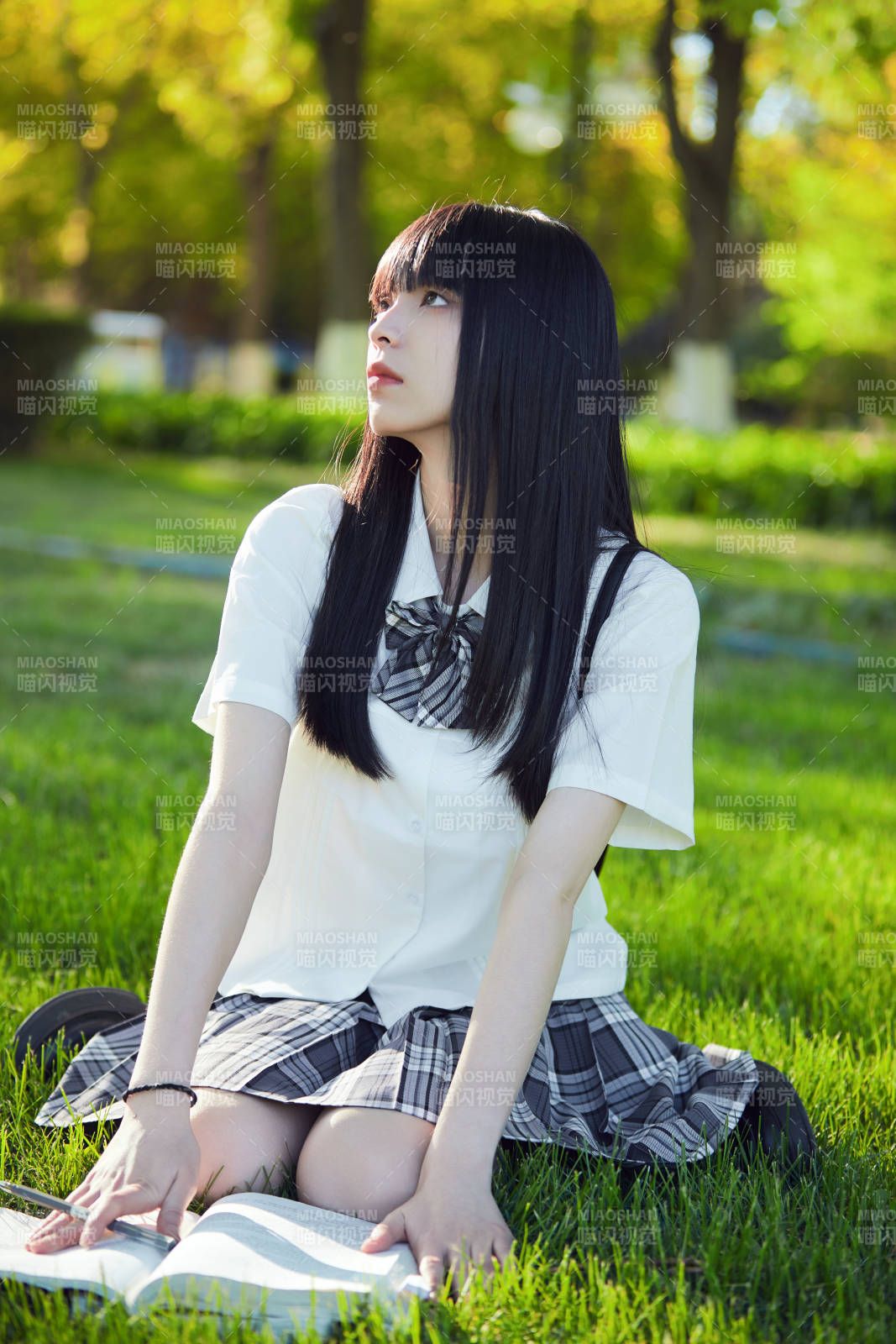 在戶外草坪看書學(xué)習(xí)的女生