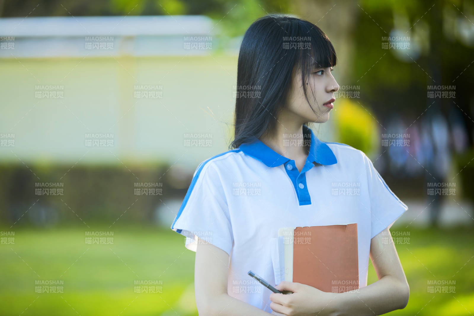 校园里抱着书的高中女生