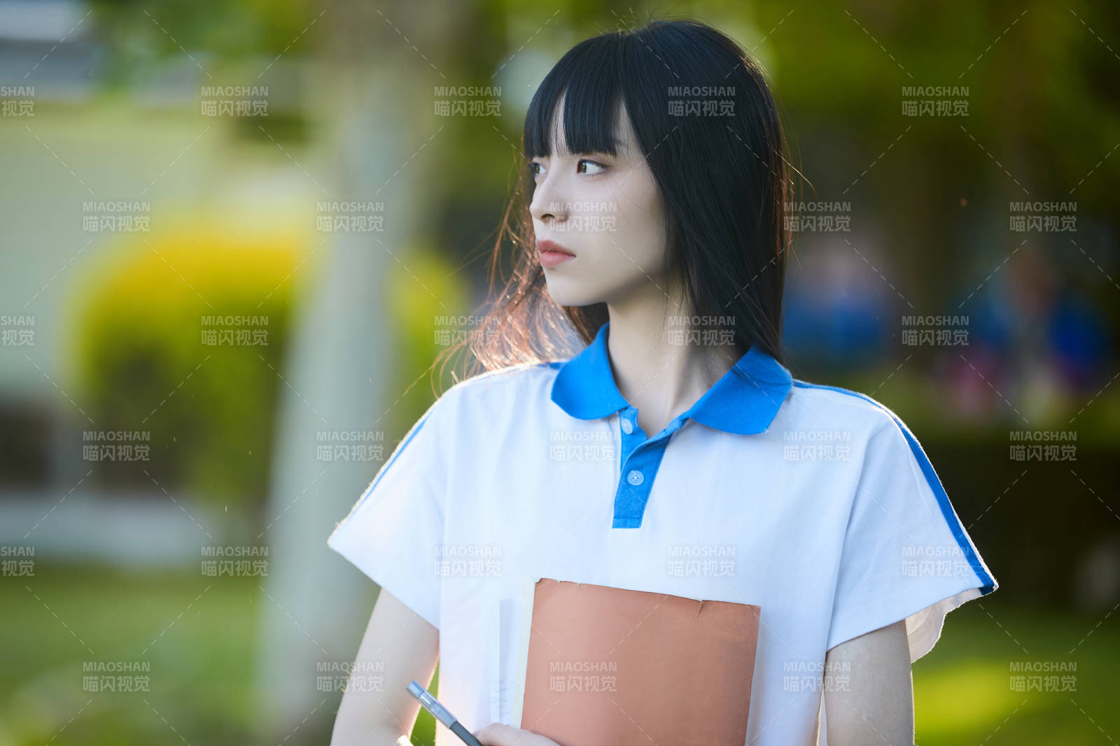 校园里抱着书的高中女生