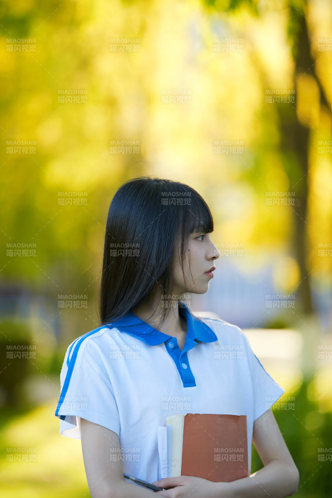 校园里抱着书的高中女生