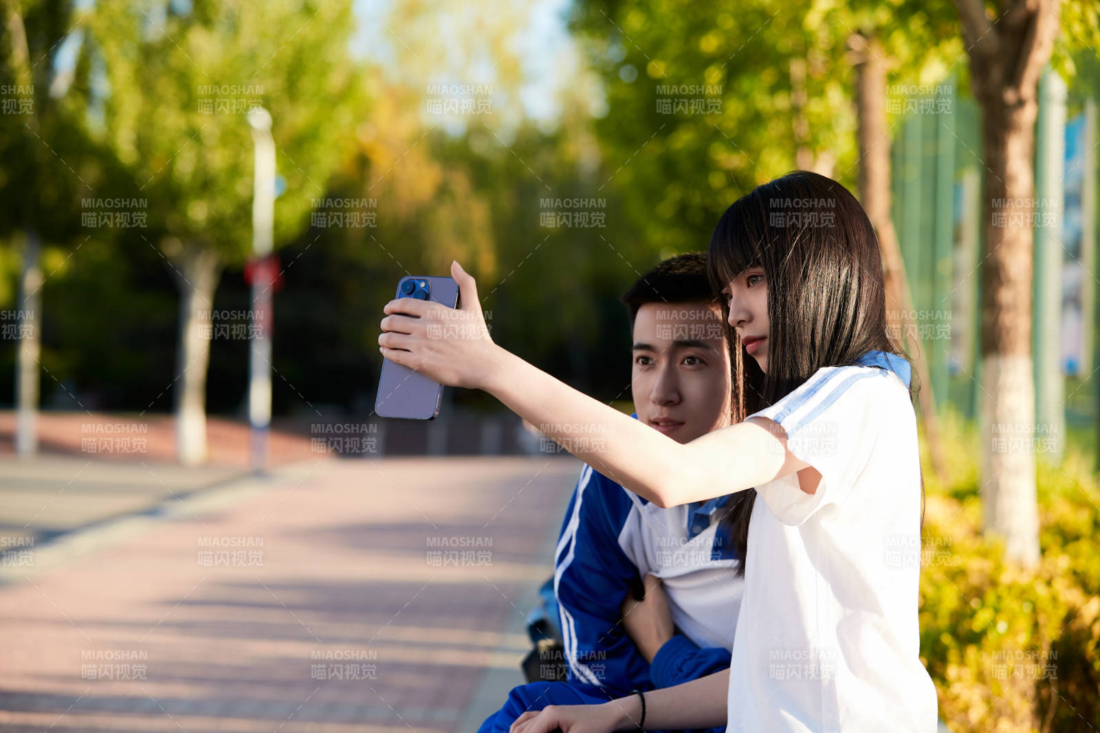 校園里用手機自拍的高中生