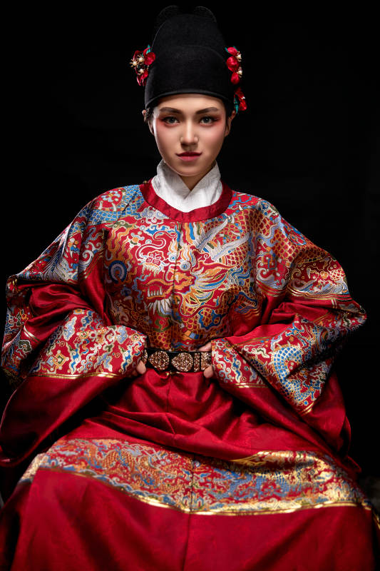 黑色背景下身着明代飞鱼服的青年女性