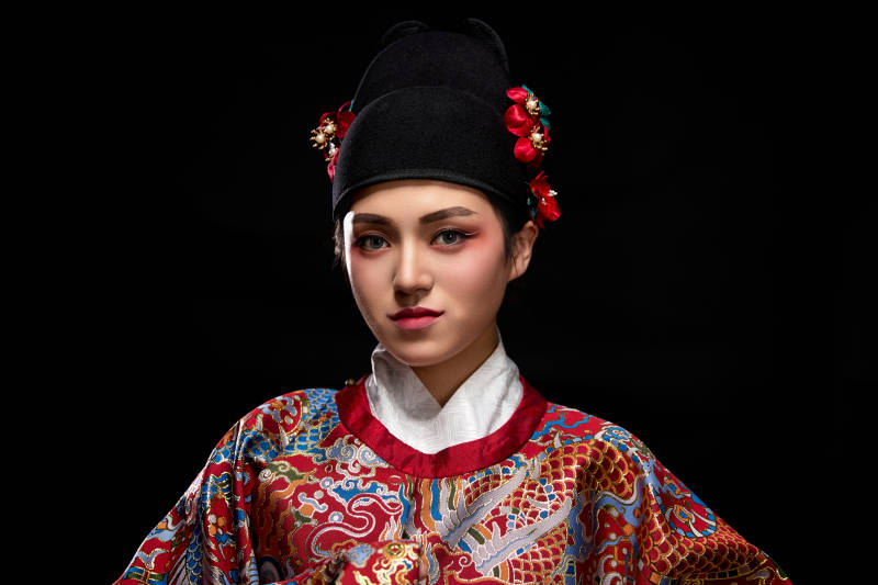 黑色背景下身着明代飞鱼服的青年女性