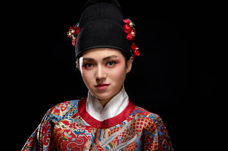 黑色背景下身着明代飞鱼服的青年女性