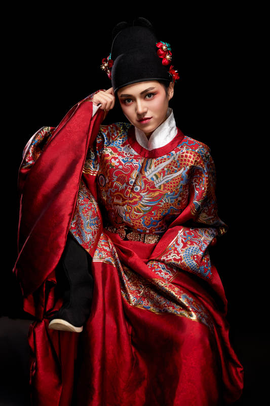 黑色背景下身着明代飞鱼服的青年女性