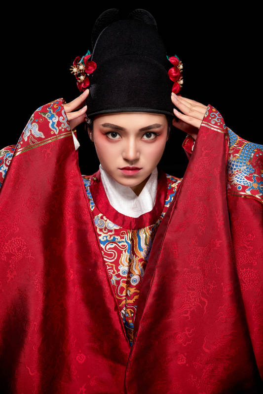 黑色背景下身着明代飞鱼服的青年女性