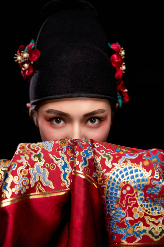 黑色背景下身着明代飞鱼服的青年女性