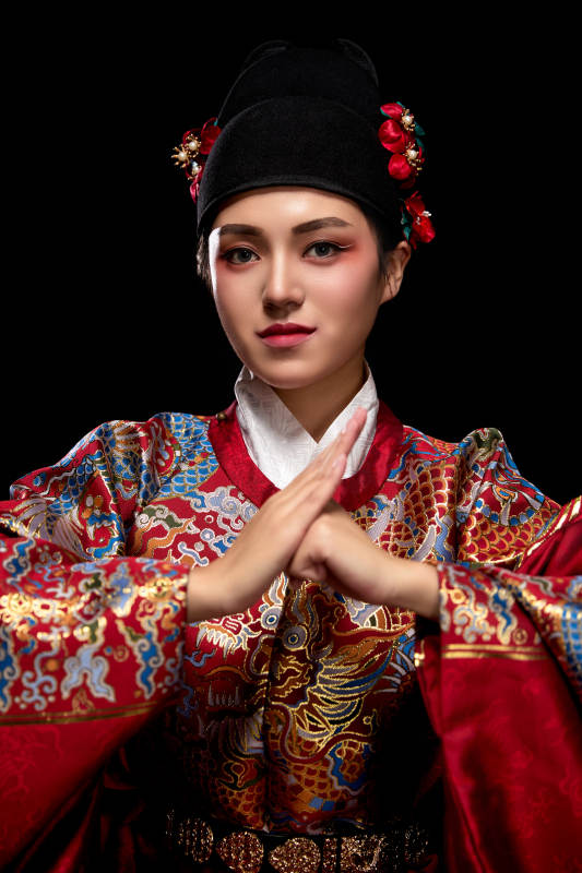 黑色背景下身着明代飞鱼服的青年女性