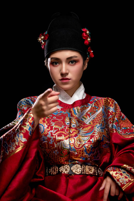 黑色背景下身着明代飞鱼服的青年女性