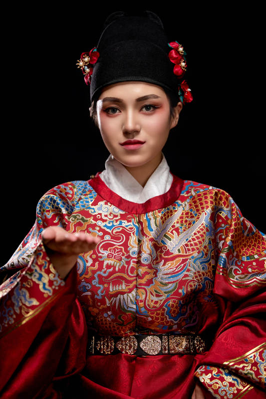 黑色背景下身着明代飞鱼服的青年女性