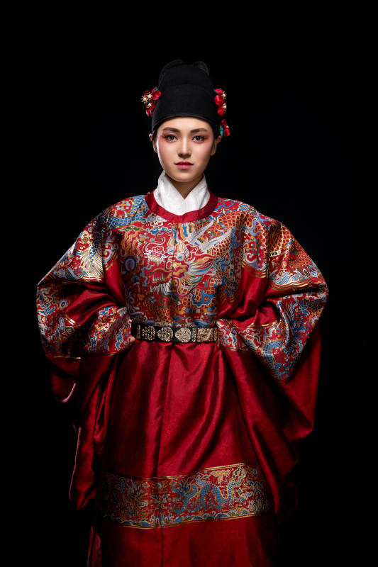 黑色背景下身着明代飞鱼服的青年女性