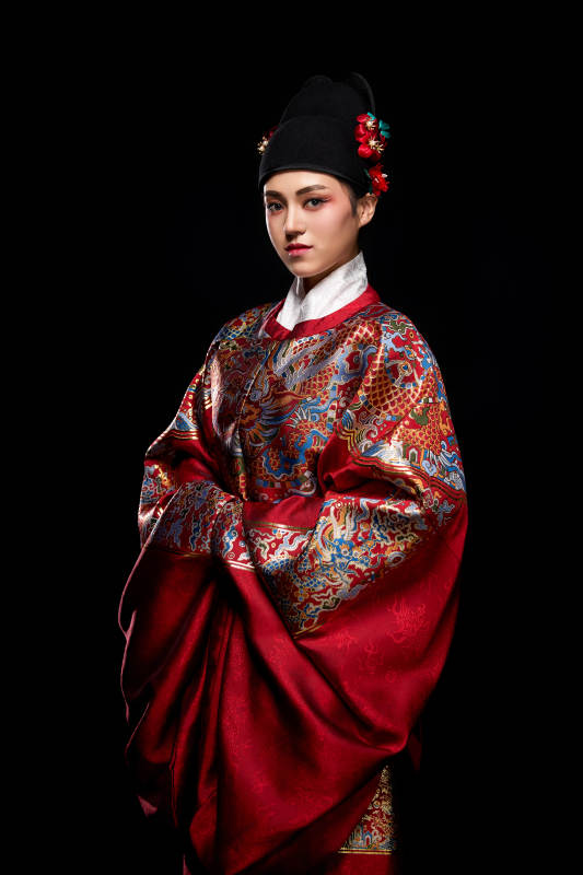 黑色背景下身着明代飞鱼服的青年女性