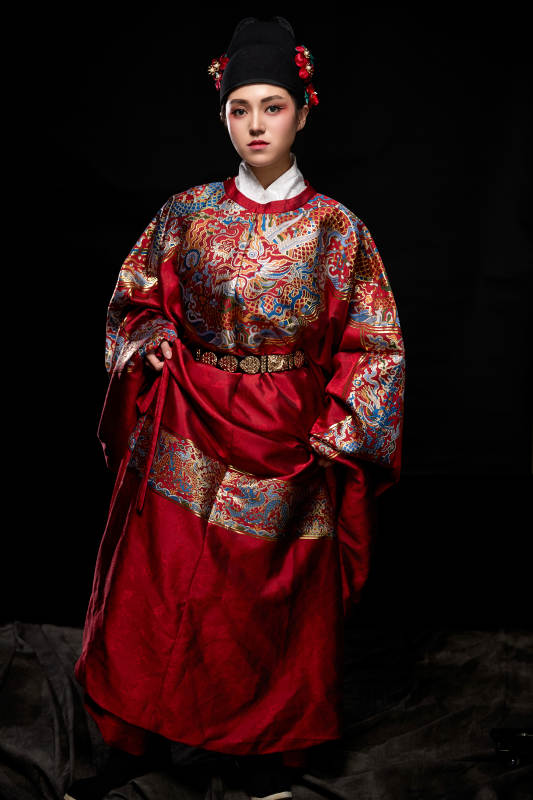 黑色背景下身着明代飞鱼服的青年女性