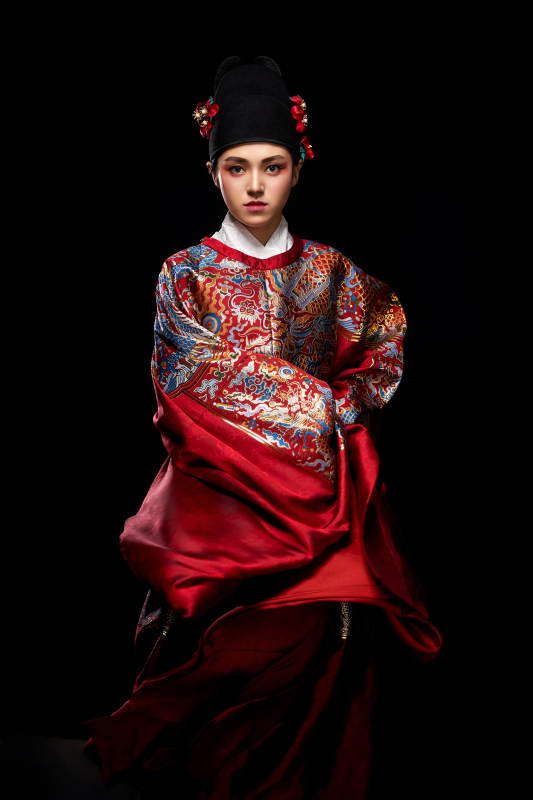 黑色背景下身着明代飞鱼服的青年女性