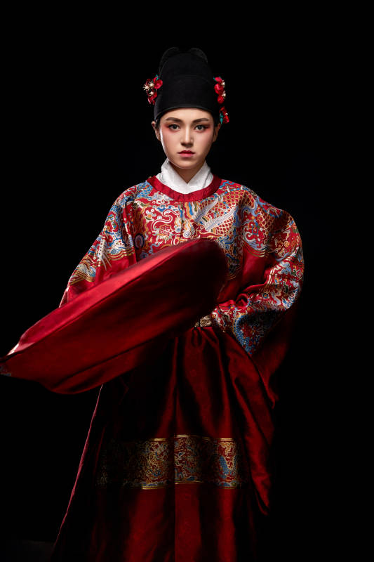 黑色背景下身着明代飞鱼服的青年女性