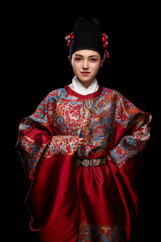 黑色背景下身着明代飞鱼服的青年女性