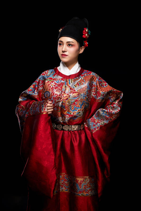 黑色背景下身着明代飞鱼服的青年女性