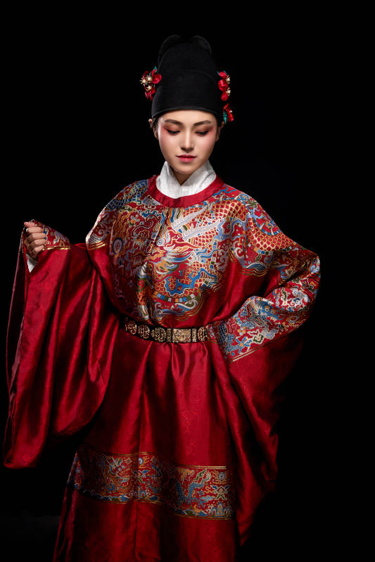 黑色背景下身着明代飞鱼服的青年女性