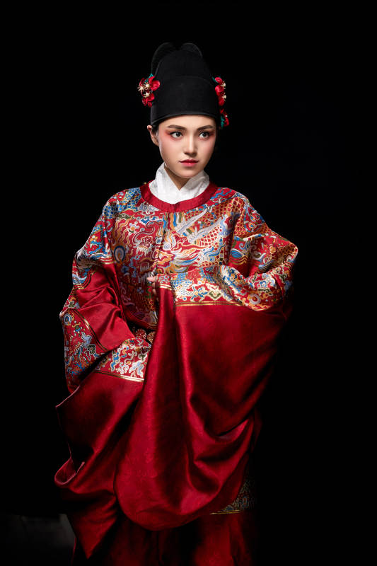 黑色背景下身着明代飞鱼服的青年女性
