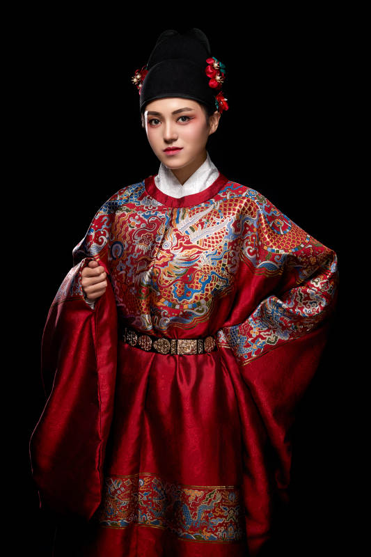黑色背景下身着明代飞鱼服的青年女性