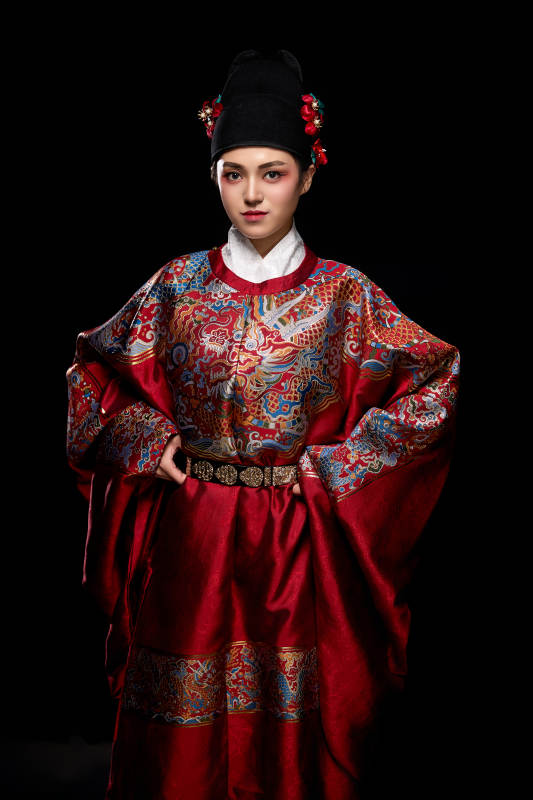 黑色背景下身着明代飞鱼服的青年女性