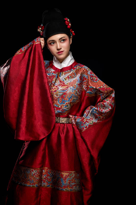 黑色背景下身着明代飞鱼服的青年女性