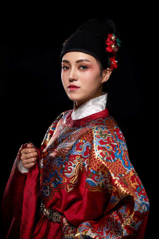 黑色背景下身着明代飞鱼服的青年女性