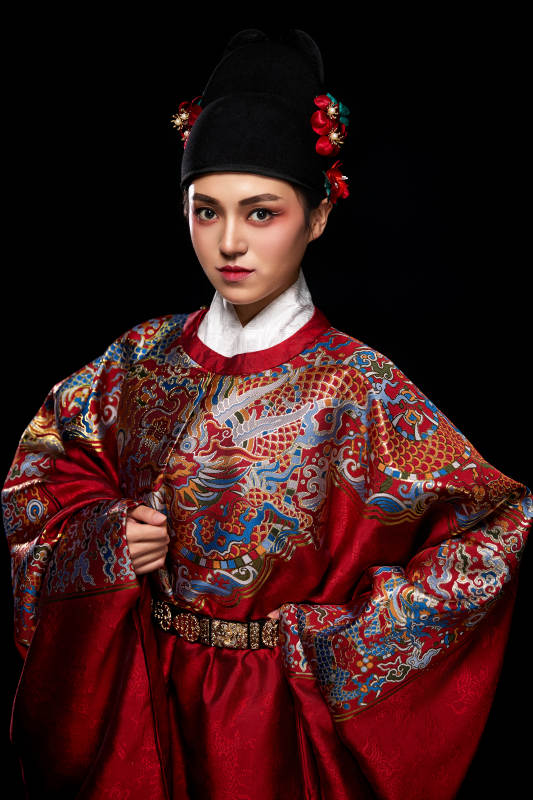 黑色背景下身着明代飞鱼服的青年女性