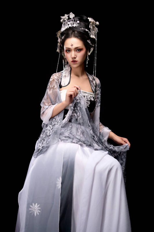 坐在木桌上穿着古装仙侠服饰的东方女性