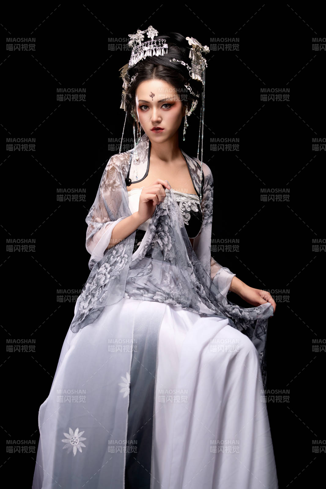 坐在木桌上穿着古装仙侠服饰的东方女性