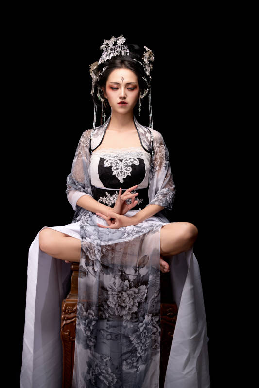 坐在木桌上穿着古装仙侠服饰的东方女性