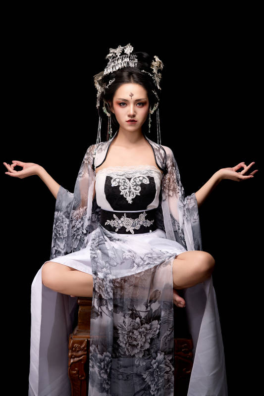 坐在木桌上穿着古装仙侠服饰的东方女性