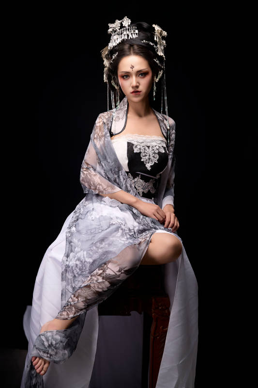 坐在木桌上穿着古装仙侠服饰的东方女性