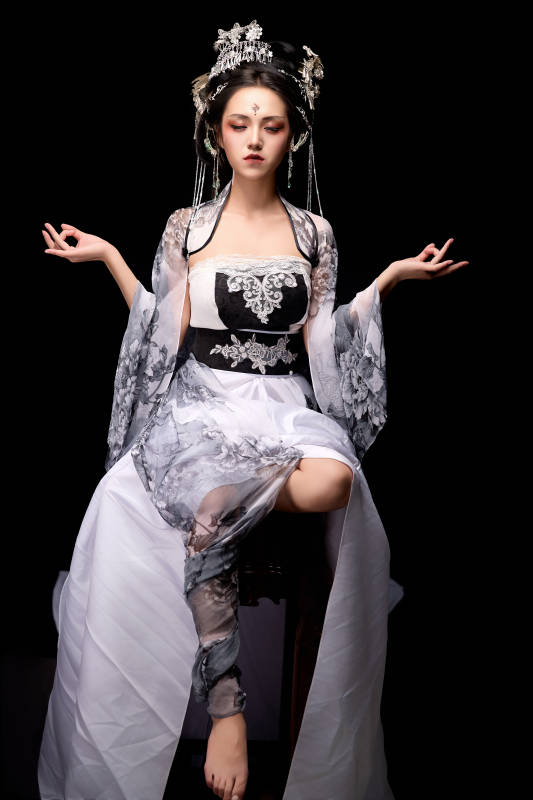 坐在木桌上穿着古装仙侠服饰的东方女性