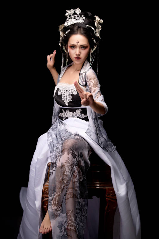 坐在木桌上穿着古装仙侠服饰的东方女性