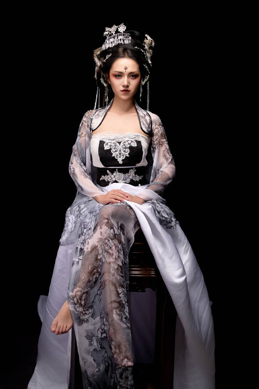 坐在木桌上穿着古装仙侠服饰的东方女性