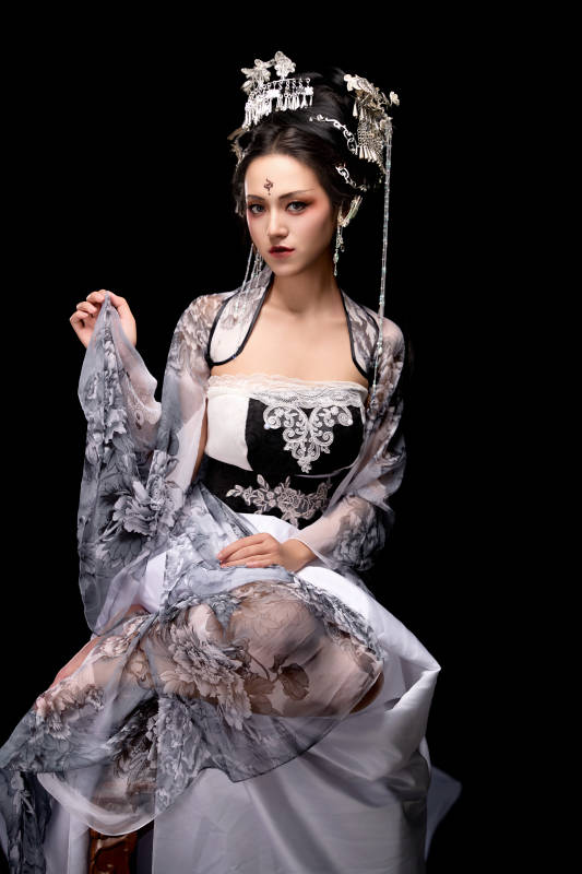 坐在木桌上穿着古装仙侠服饰的东方女性