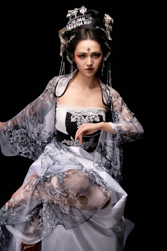 坐在木桌上穿着古装仙侠服饰的东方女性