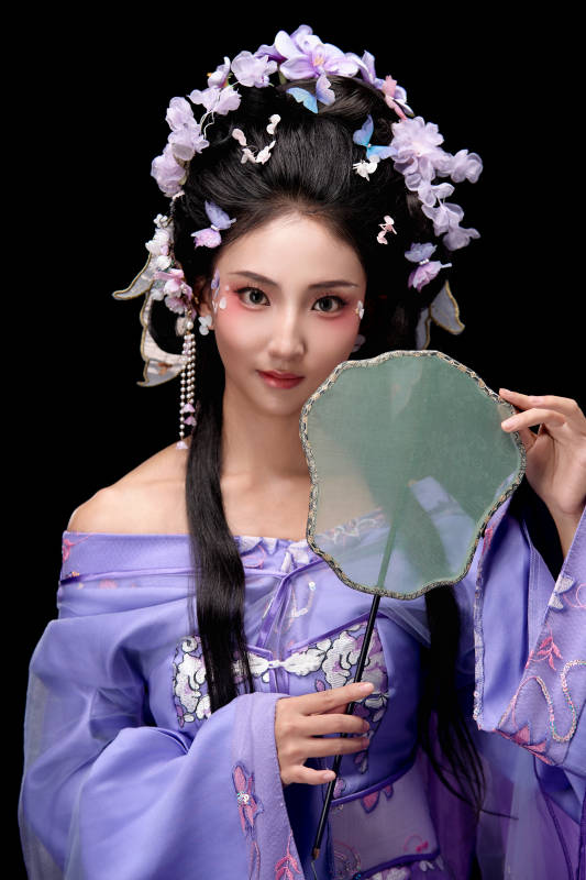 身着簪花仕女装扮手持轻扇的东方女性