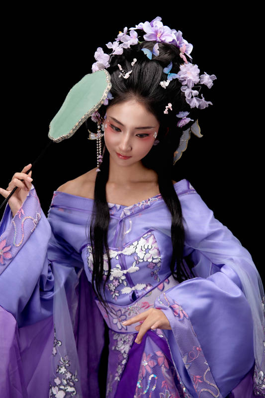 身著簪花仕女裝扮手持輕扇的東方女性