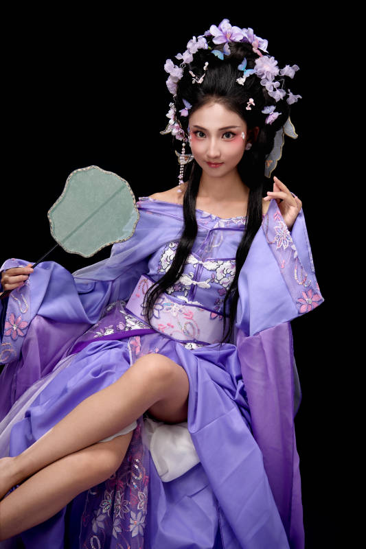 身著簪花仕女裝扮坐在木桌上的東方女性