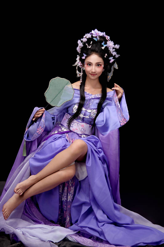 身著簪花仕女裝扮坐在木桌上的東方女性