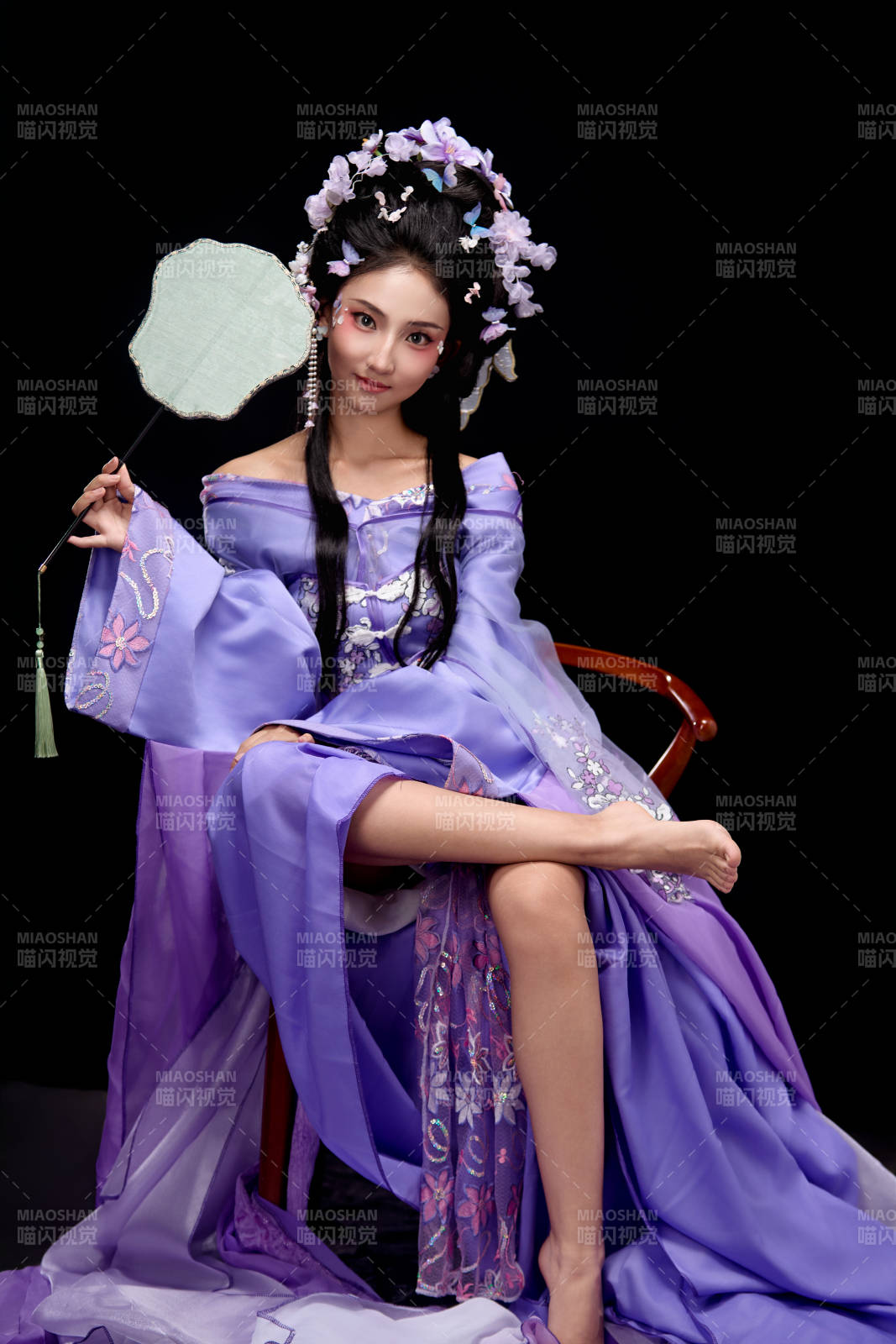 身着簪花仕女装扮坐在木桌上的东方女性