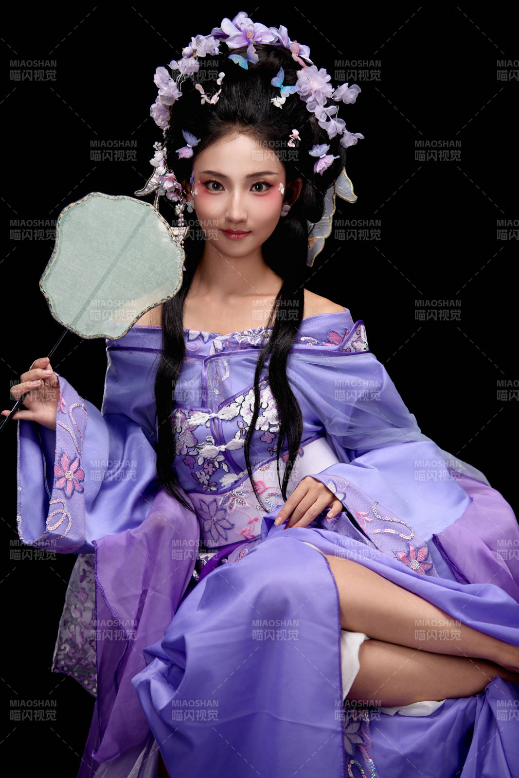 身著簪花仕女裝扮坐在木桌上的東方女性