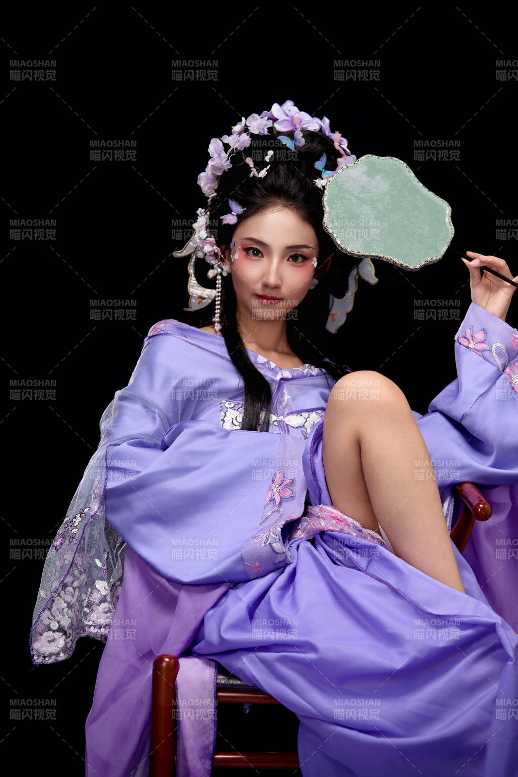 身着簪花仕女装扮坐在木桌上的东方女性