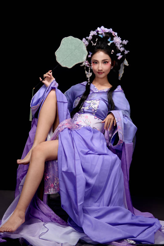 身著簪花仕女裝扮坐在木桌上的東方女性