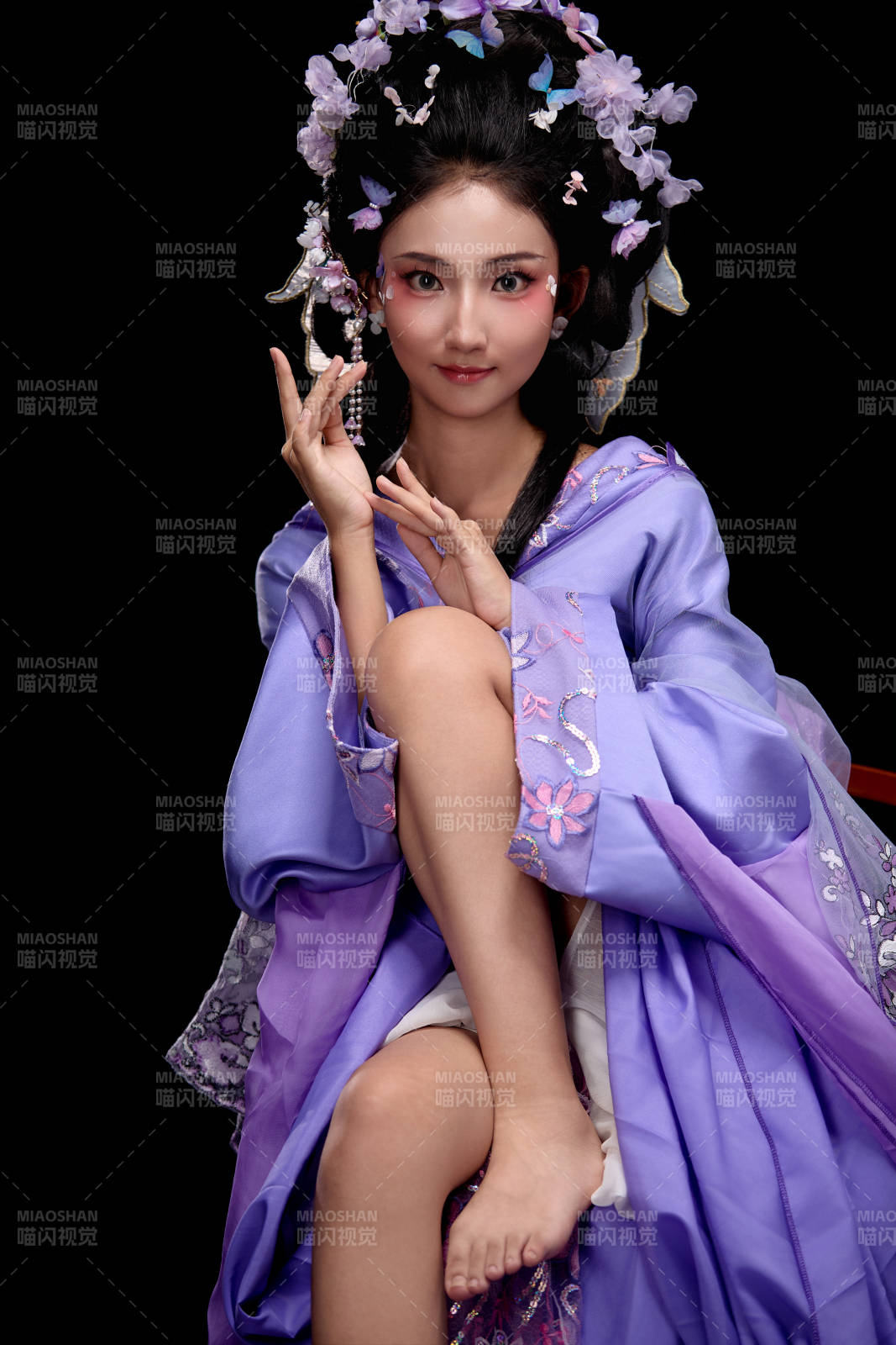 身着簪花仕女装扮坐在木桌上的东方女性图片