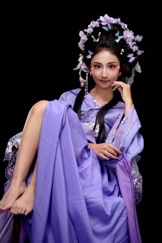 身著簪花仕女裝扮坐在木桌上的東方女性